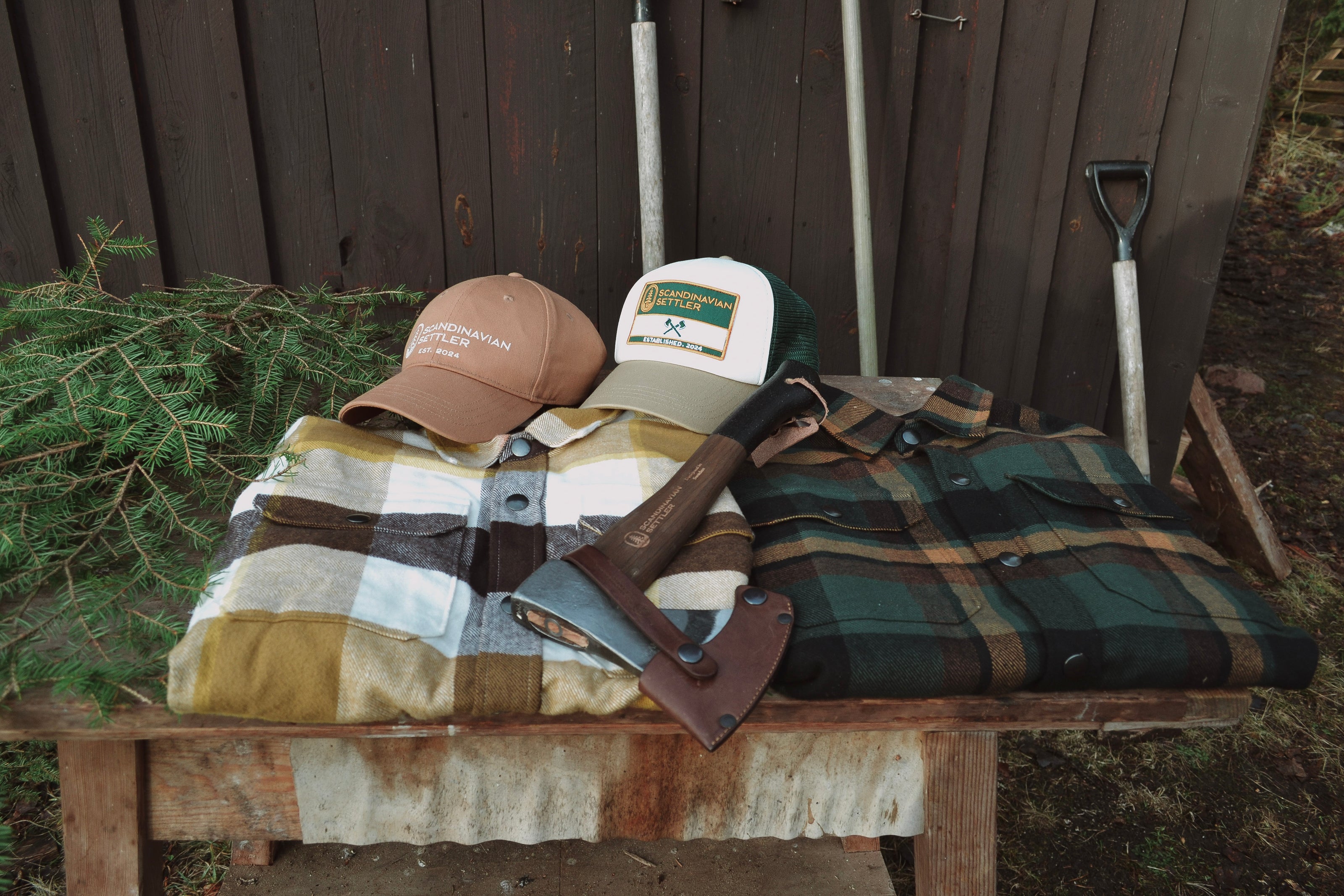Flanellskjortor, kepsar och yxa i utomhusmiljö för friluftsliv